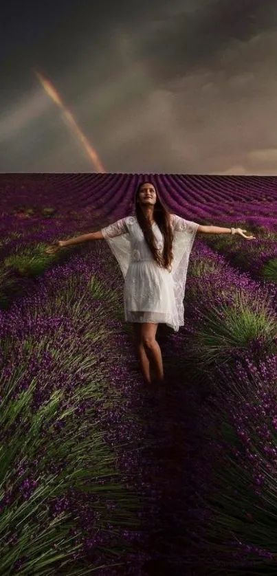 Woman in a lavender field with a rainbow in the sky.