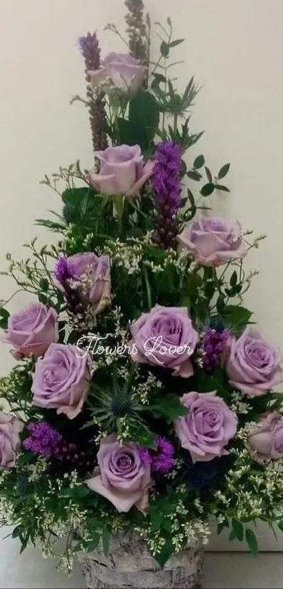 Lavender rose arrangement with lush greenery in vase.