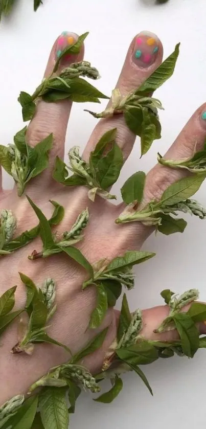 Hand wrapped in green leaves with colorful nails design.