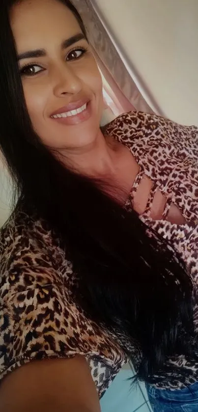 Woman in leopard print top with long hair and casual jeans.