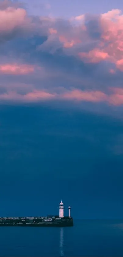 Lighthouse with pink sunset clouds over blue ocean.