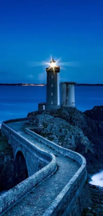 Serene lighthouse by the ocean at night with a starry sky.