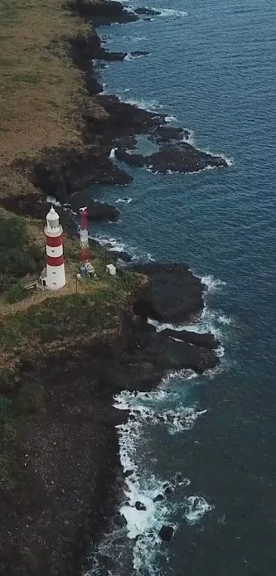 Aerial view of lighthouse on a rocky coastline with ocean waves.