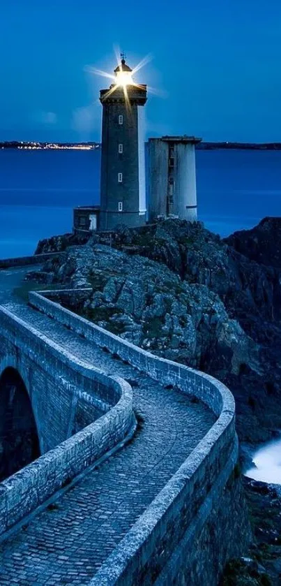 Lighthouse shining bright on a rocky ocean cliff at night.