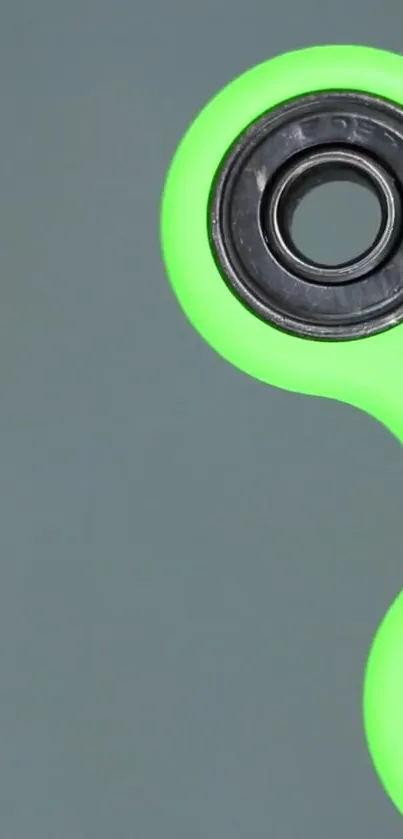 Lime green fidget spinner on a grey background, sleek design.