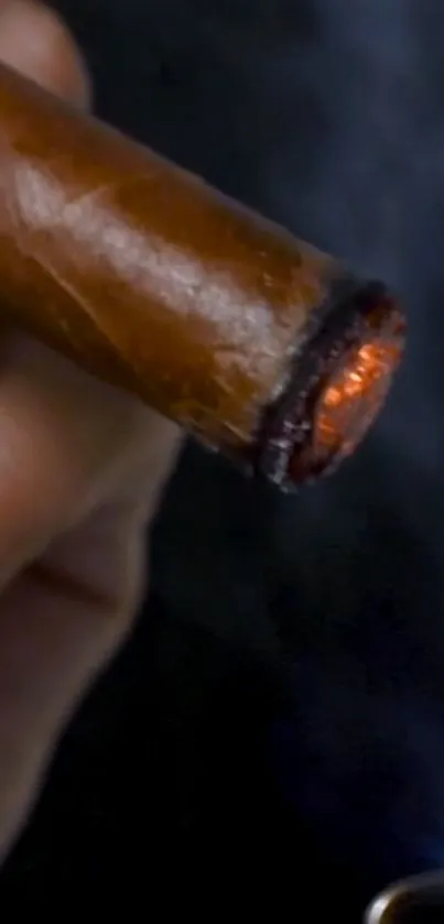 Close-up of a lit cigar with glowing embers and smoke.