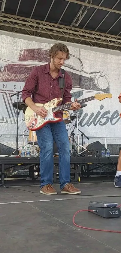 Guitarist performing live on stage at a concert event.