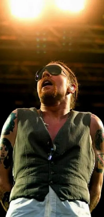 Performer on stage with bright lights and tattoos at a live concert.