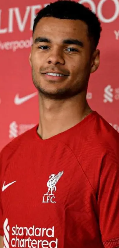 Liverpool FC red wallpaper with a football player and team logos.