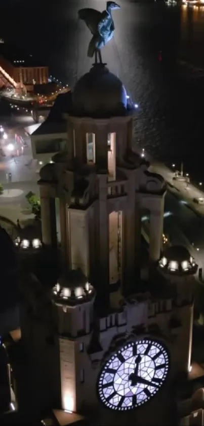 Liverpool clock tower illuminated at night over waterfront.