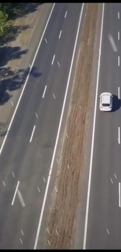 Aerial view of a car driving on an empty highway.