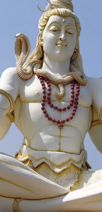 Serene statue of Lord Shiva under a clear blue sky.