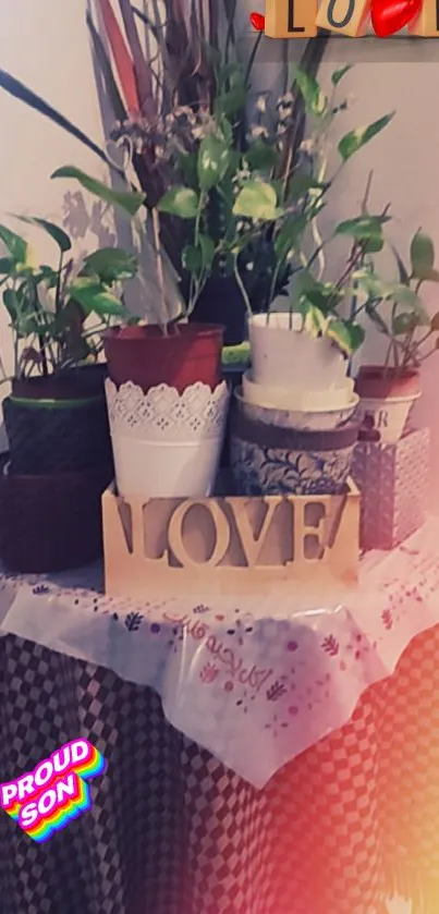 Potted plants and LOVE sign with warm tones on a decorative table.