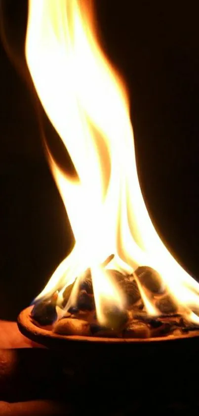 Luminous flame in a dark setting as mobile wallpaper.