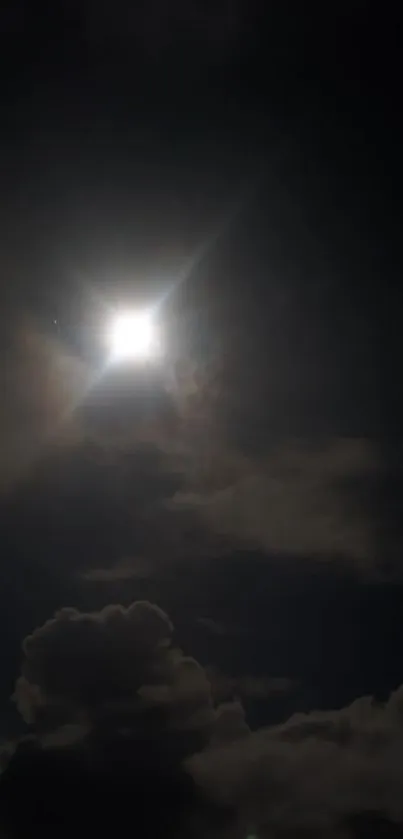 Moonlit sky with glowing clouds in a dark serene setting.