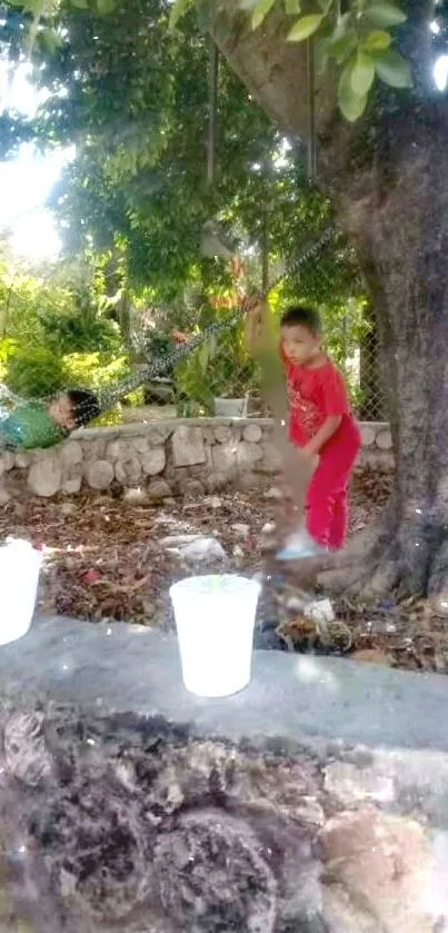 Kids playing under a tree in a garden-filled mobile wallpaper.