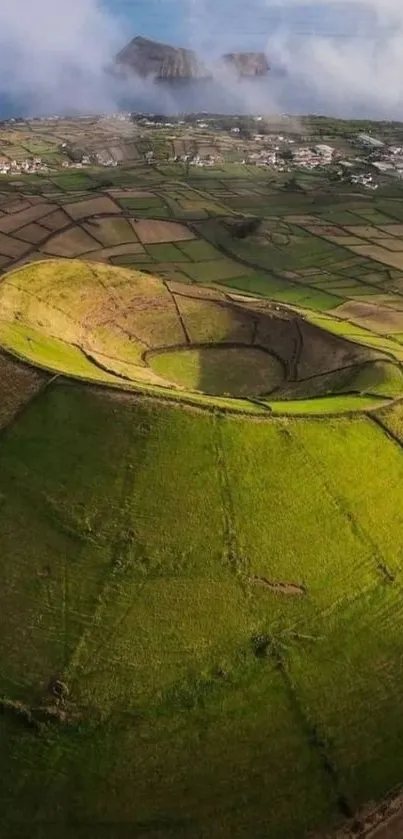 Aerial shot of a lush green volcanic crater surrounded by fields.