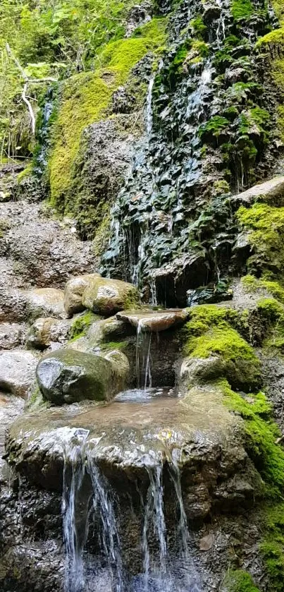 Lush green waterfall cascading over moss-covered rocks, creating a serene nature scene.