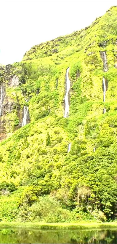 Lush green mountain with cascading waterfalls.