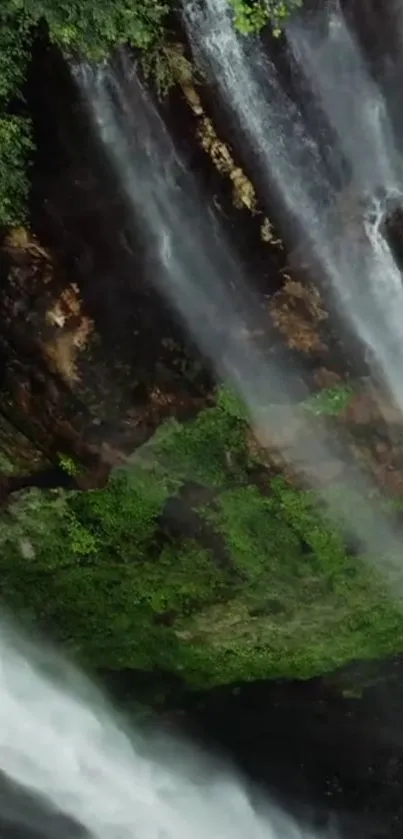 Lush waterfall flowing over rocks with greenery.