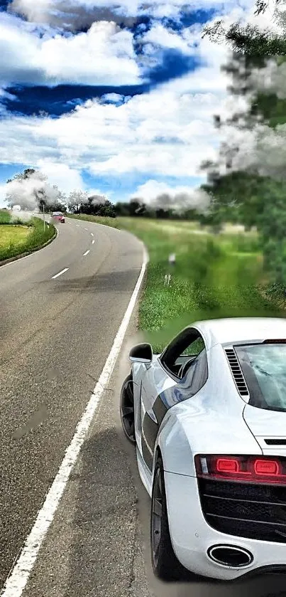 Luxury sports car on a scenic road with lush greenery and a vibrant sky.