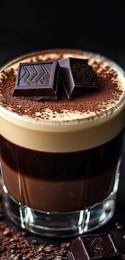 Glass of creamy chocolate coffee topped with chocolate pieces.