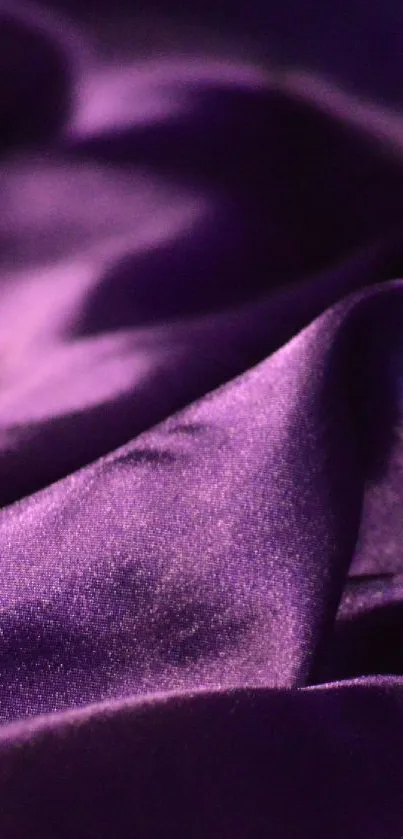 Luxurious folds of purple satin cloth wallpaper.