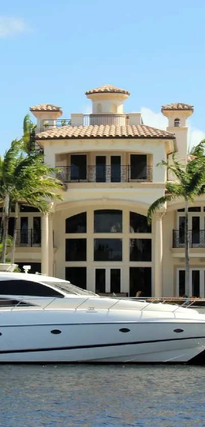 Luxurious yacht docked by a tropical mansion under a clear sky.