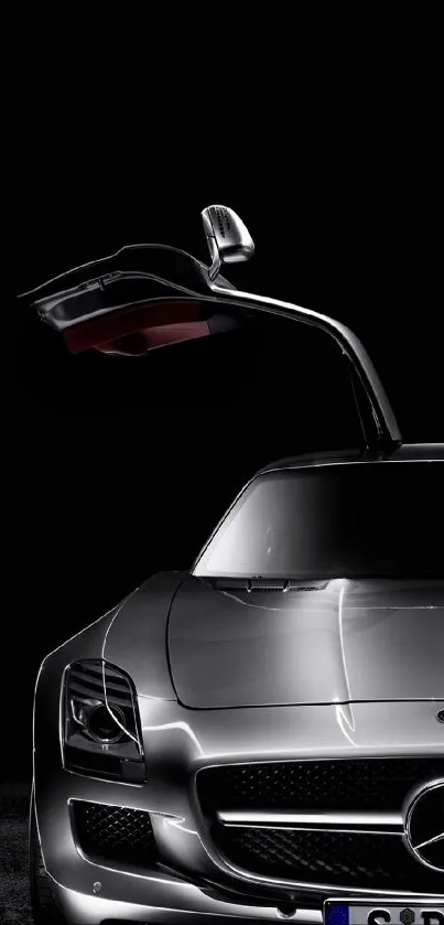 Luxury car with gullwing door on dark background.