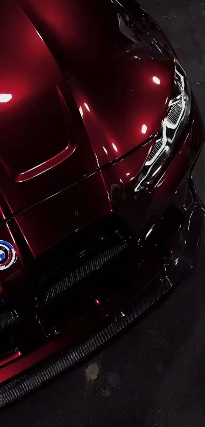 Close-up of a luxury car hood with maroon finish and sleek design.