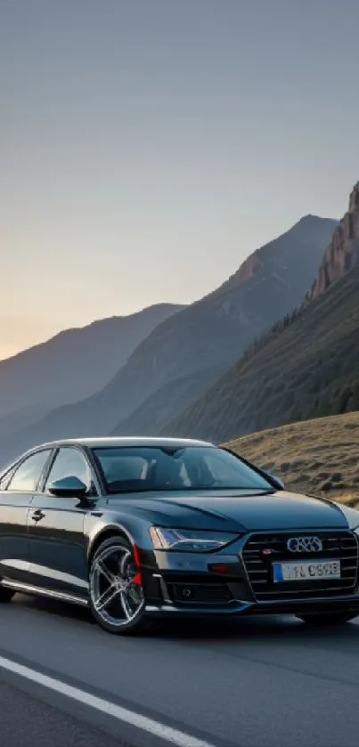 Sleek luxury car on a scenic mountain road at sunset.