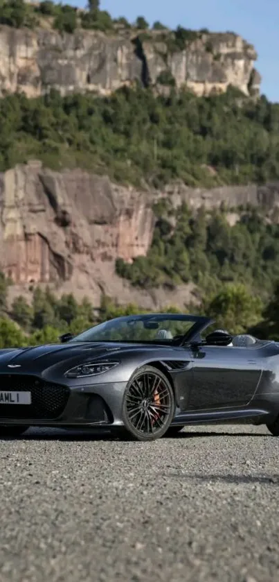 Luxury car set against a scenic mountain backdrop on a sunny day.