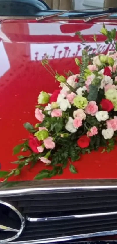 Luxury car hood with floral bouquet on red surface.