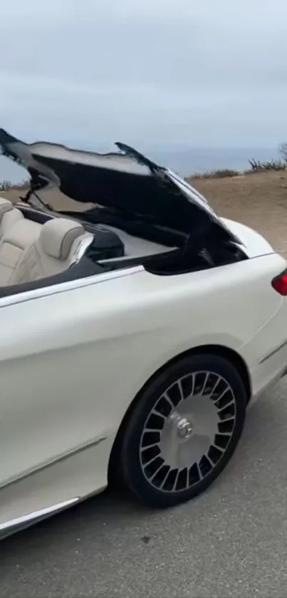 Luxury beige convertible car by the beach road.