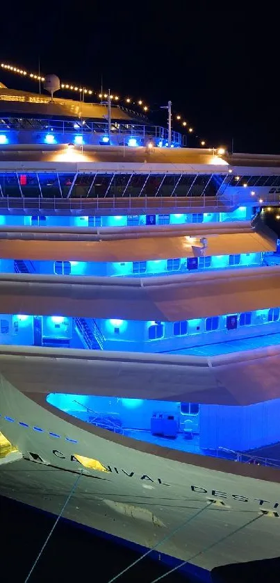Luxurious cruise ship glowing with blue lights at night.