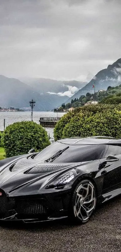 Sleek black sports car by a tranquil lakeside with lush greenery and mountains.