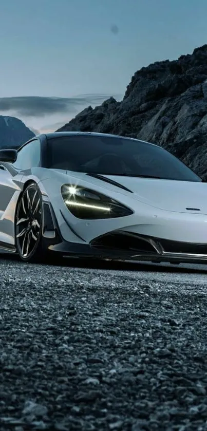 White sports car on scenic mountain road with rocky backdrop.