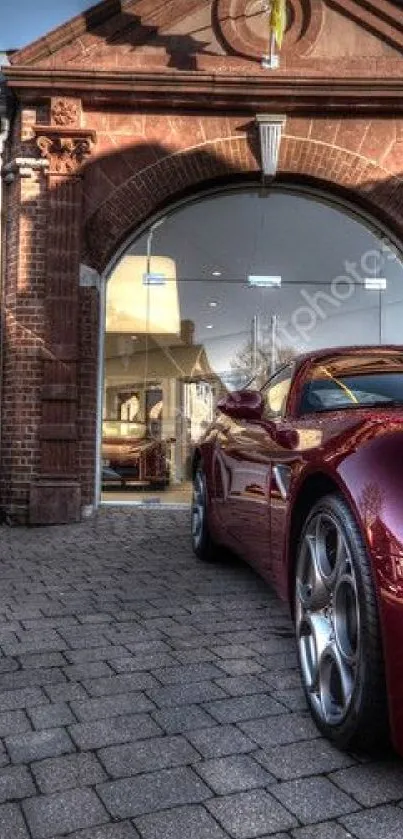 Luxury maroon sports car in front of elegant brick building.