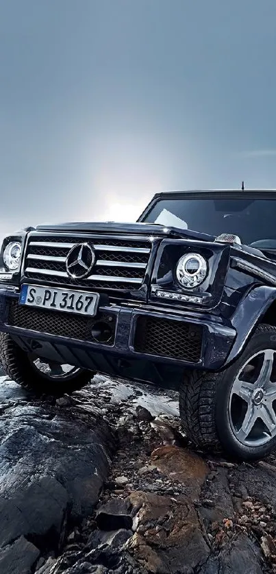 Luxury SUV on rocky terrain beneath a blue sky.