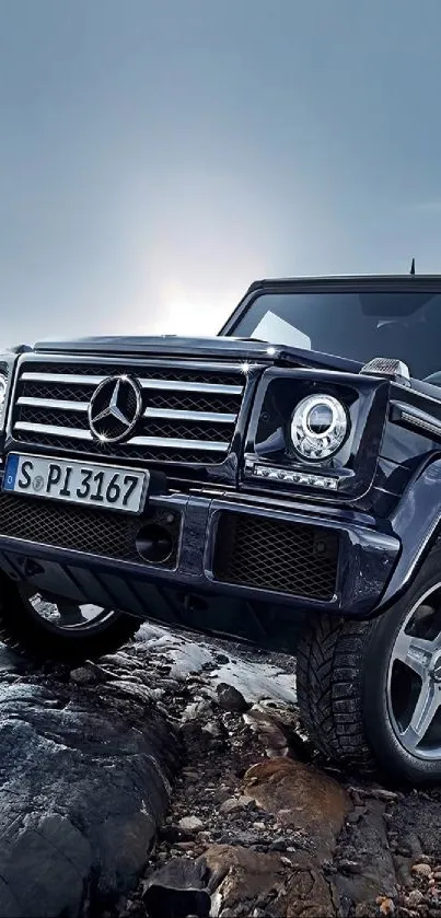 Luxury SUV on rocky terrain under a cloudy sky.