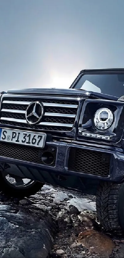 Luxury Mercedes SUV on rocky terrain basking under a moody sky.