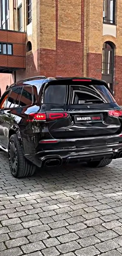 Black luxury SUV in urban street setting with brick buildings.