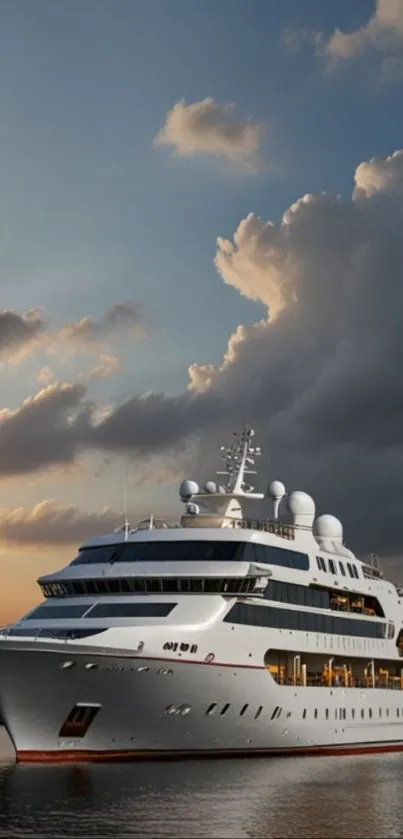 Luxury yacht sailing at sunset with calm waters and cloudy sky.