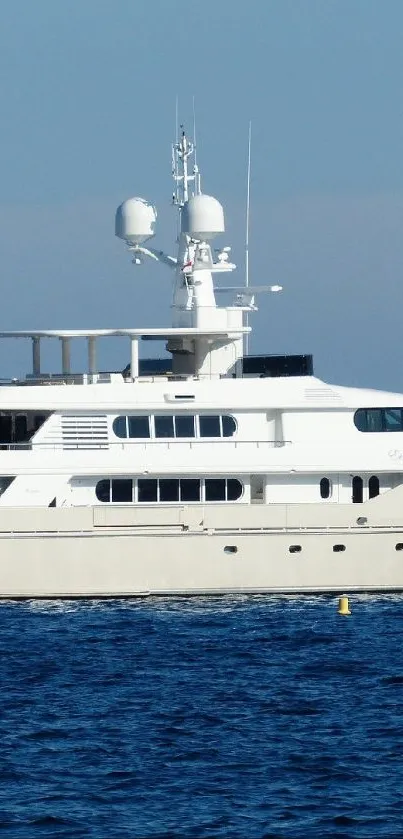 Luxury yacht sailing on calm blue sea under clear sky.