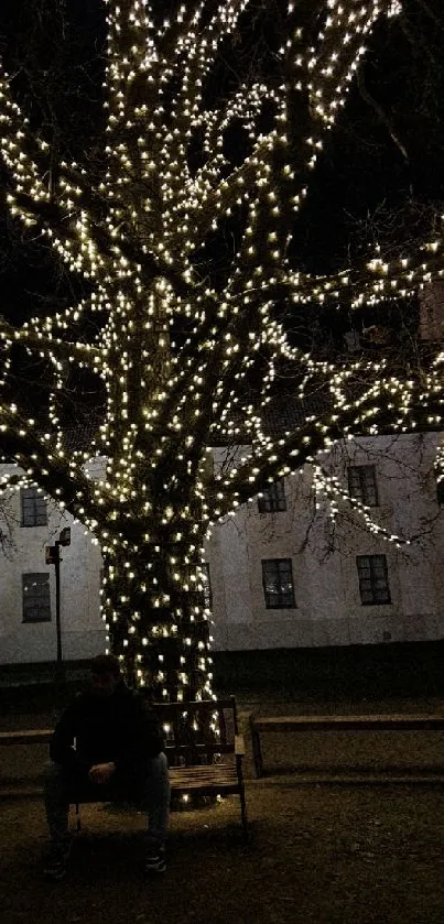 Tree wrapped in bright fairy lights at night with a peaceful atmosphere.