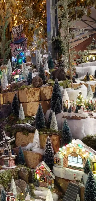 Miniature snowy village with lights and trees in a wintery holiday scene.