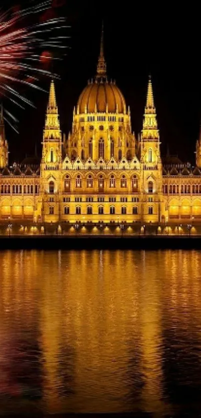 Illuminated building with fireworks at night reflected in water.