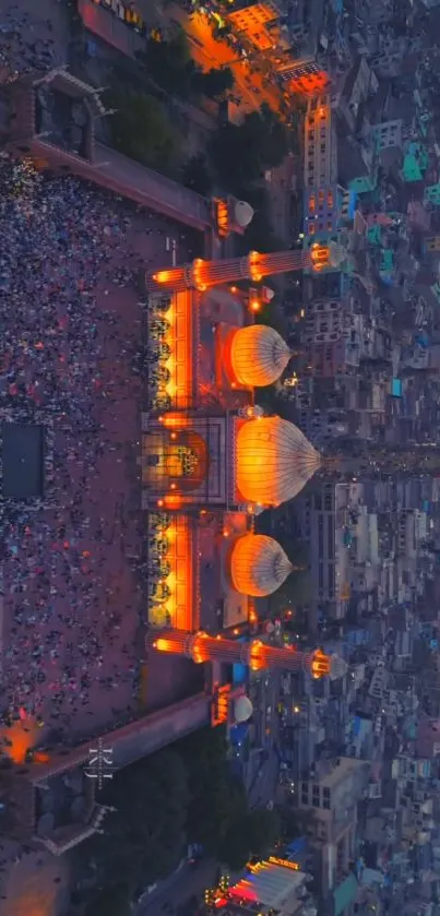 Aerial view of a lit mosque with a vibrant cityscape.