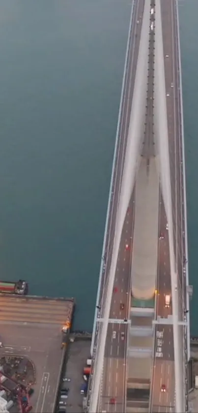 Aerial view of bridge over blue waters at sunset.