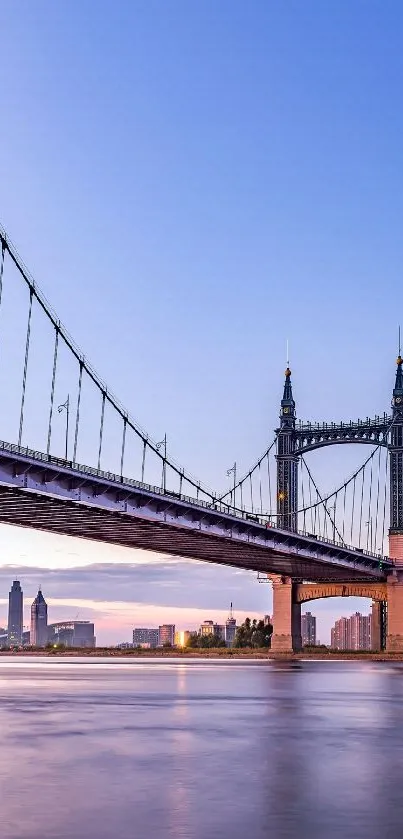 Beautiful suspension bridge at sunset with city skyline in background.